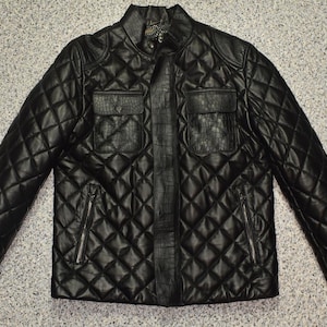 May include: Black quilted leather jacket with a stand-up collar, two chest pockets, and two zipped side pockets. The jacket features a diamond pattern and a textured central panel.