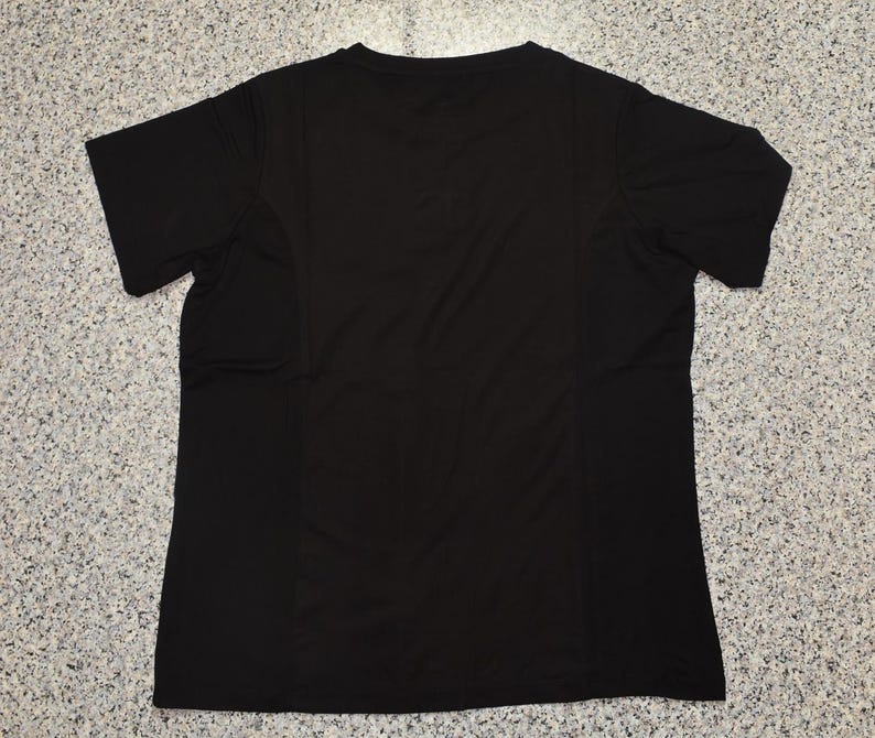 May include: A plain black short-sleeved t-shirt. The shirt has a V-neck and is made of a lightweight, possibly athletic material. The back of the shirt is visible, showing seams and a simple design.