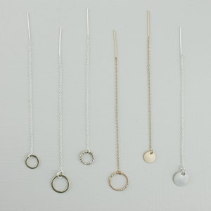 May include: Five different gold and silver chain necklaces with various pendant styles, including a circle, a twisted circle, a small round disc, and a larger round disc.