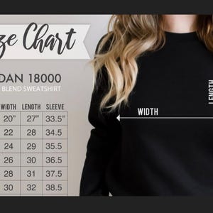 May include: A size chart for a Gildan 18000 heavy blend sweatshirt. The chart shows measurements for width, length, and sleeve length in inches for sizes S through 3XL. The image also shows a person wearing a black sweatshirt.
