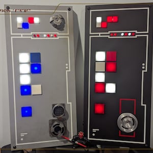 Peut inclure: Deux panneaux rectangulaires avec divers composants carrés et circulaires éclairés. Un panneau est gris avec des lumières bleues, blanches et rouges. L'autre est noir avec des lumières rouges et blanches. Une petite figurine avec un sabre laser rouge est en bas.