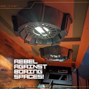 May include: Two circular, metallic gray ceiling-mounted light fixtures with a segmented, industrial design. The lights emit a bright white glow. The text "REBEL AGAINST BORING SPACES!" is printed in white, blocky, futuristic-style lettering on the left side.
