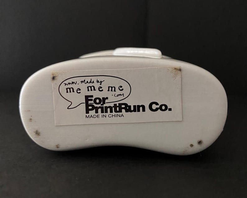 May include: White plastic container with a black label that reads "www.Made by me meme me.com For PrintRun Co. Made in China"
