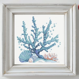 Può includere: Uno schema di punto croce con una barriera corallina blu con tre conchiglie e un ramo di corallo rosa.