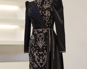 May include: A black formal gown with long sleeves and a high neckline. The bodice and skirt feature intricate gold sequin and bead embellishments. The dress has a draped design across the bodice and a flowing skirt, creating an elegant silhouette.