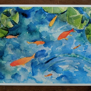 May include: Watercolor painting of a pond with lily pads and orange goldfish swimming. The water is a light blue color and the lily pads are green.