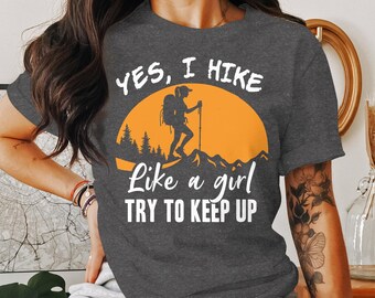 May include: Gray t-shirt with a white graphic that says "Yes, I hike like a girl try to keep up". The graphic also features a silhouette of a hiker with a backpack and a hiking stick.