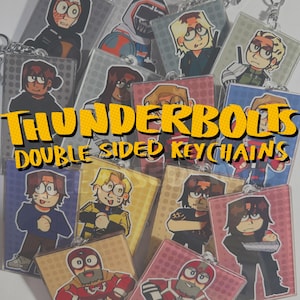 May include: A collection of double-sided keychains featuring various cartoon characters. The keychains have a rectangular shape with a silver chain. The text "THUNDERBOLTS DOUBLE SIDED KEYCHAINS" is displayed in yellow and orange.
