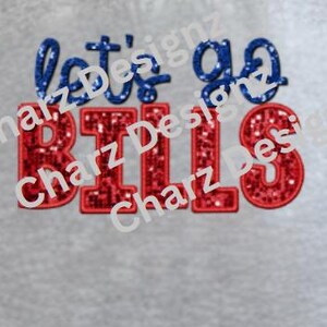 May include: A gray fabric with the text "let's go BILLS" embroidered in blue and red glitter. The text is in a playful, cursive font. The design is centered on the fabric.