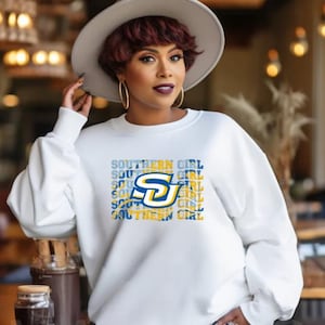 May include: White sweatshirt with a blue and yellow graphic design that says "Southern Girl" with a stylized "S" in the center.