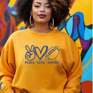 May include: A yellow sweatshirt with a blue peace sign, heart, and football graphic. The text "Peace Love Jaguars" is printed below the graphic.