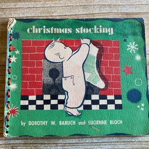 May include: A vintage children's book titled "Christmas Stocking" by Dorothy W. Baruch and Lucienne Bloch. The cover features a green background with a red brick fireplace and a child holding a green and white stocking.