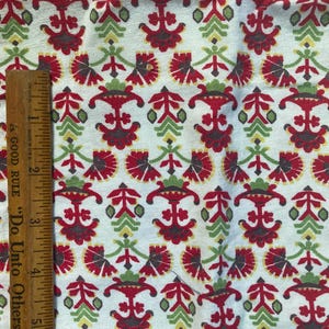 May include: White fabric with a repeating pattern of red, green, and gray stylized flowers. The fabric is measured with a ruler that reads "Good Rule - Do Unto Others".