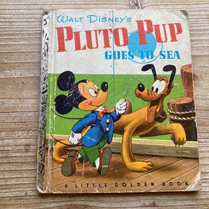 May include: A vintage Little Golden Book featuring Walt Disney's Pluto Pup Goes to Sea. The cover shows Pluto the dog and Mickey Mouse in a colourful illustration.