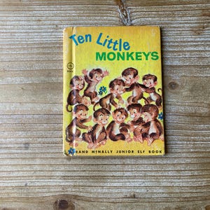May include: A yellow book with the title "Ten Little Monkeys" and a picture of ten monkeys on the cover. The book is a Rand McNally Junior Elf Book.