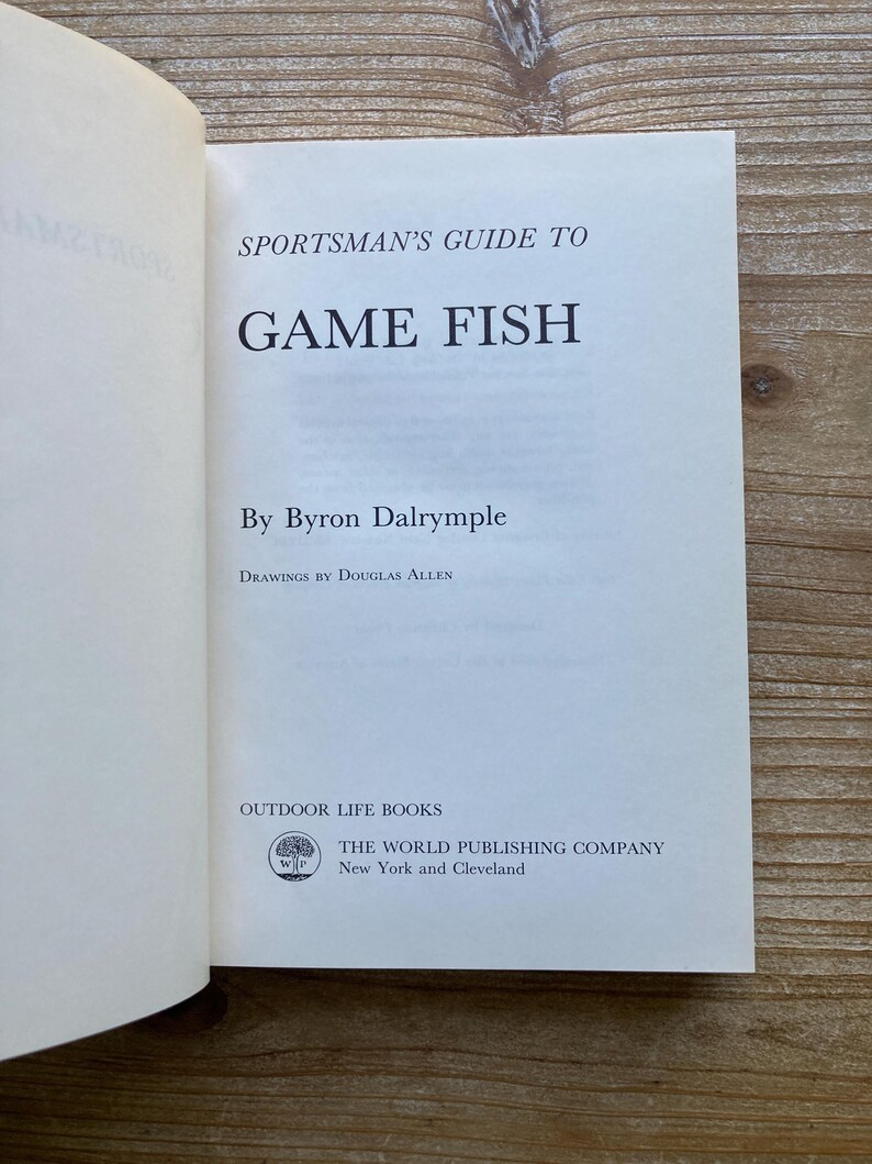 以下が含まれることがあります： バイロン・ダルリンプル著「スポーツマンズ・ガイド・トゥ・ゲーム・フィッシュ」というタイトルの白い本の表紙。本の表紙には、「ドグラス・アレンによる図版」と「アウトドア・ライフ・ブックス」の文字と、木のロゴが記載されています。