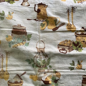 May include: A white fabric with a brown and green pattern of kitchen items, including a jar labeled "Jam", a jar labeled "Flour", and a basket of lemons. The fabric has a vintage feel.