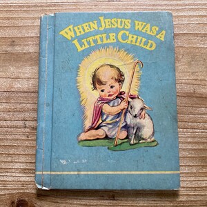 May include: A vintage children's book with a blue cover and the title "When Jesus Was A Little Child". The cover features an illustration of a young boy with a halo, holding a shepherd's staff and a lamb.