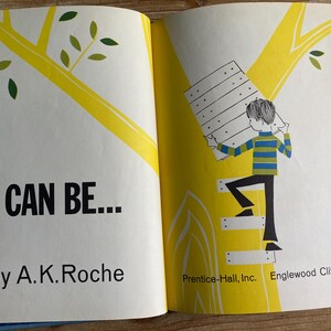 May include: Open book with the title "I Can Be..." by A.K. Roche. The illustration shows a child climbing a ladder carrying a wooden plank. The background features a yellow tree with green leaves.