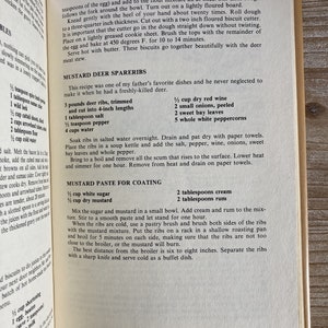 May include: A vintage cookbook page with a recipe for Mustard Deer Spareribs. The recipe includes ingredients like deer ribs, dry red wine, onions, and white peppercorns. The recipe also includes instructions for making a mustard paste for coating the ribs.
