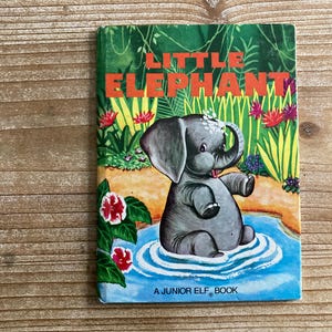 May include: A vintage children's book titled "Little Elephant." The cover features a cartoon elephant in a pond, surrounded by colorful flowers and foliage. The title is in orange letters.