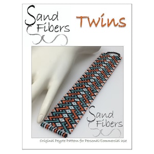 Op de afbeelding: Een kralenarmband met een chevron-patroon in zwart, oranje, turquoise en wit. De armband is op een handmodel en de tekst "Sand Fibers Twins" staat bovenaan de afbeelding. De tekst "Sand Fibers" staat ook onderaan de afbeelding.