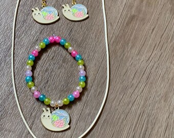 Conjunto de joyería con cadena de pulsera y pendientes.