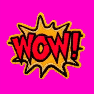 May include: A yellow and red embroidered patch with the word "WOW!" in a comic book style font.
