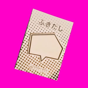 May include: A gold and white sticky note pad with a speech bubble shape and the Japanese text "fuki-dashi" printed on the front. The pad has a polka dot pattern.