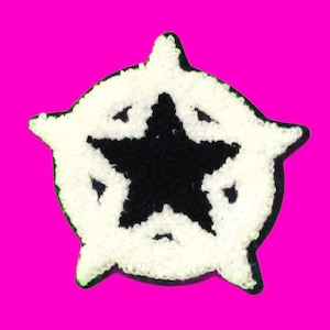 May include: A white and black felt patch with a five-pointed star in the center. The star is black and the surrounding circle is white.