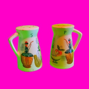 Puede incluir: Dos saleros y pimenteros de cerámica vintage con diseños de frutas verdes, amarillas y rojas. Los saleros están etiquetados con "S" y "P" y tienen un asa en el lateral.