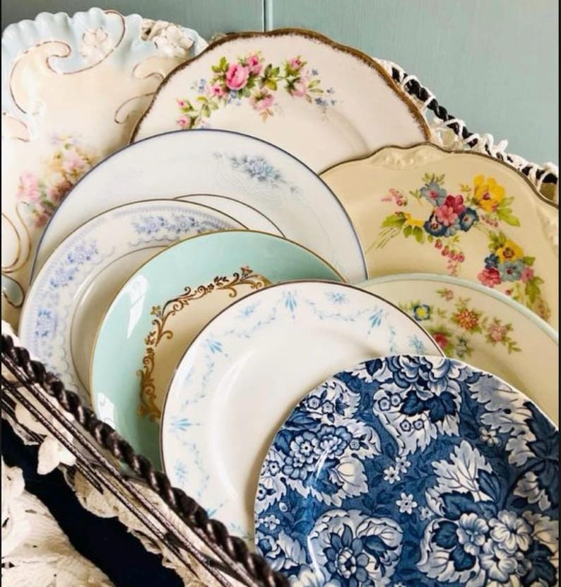 May include: A stack of vintage porcelain plates with floral and geometric patterns in shades of blue, white, and gold. The plates are arranged in a decorative display.