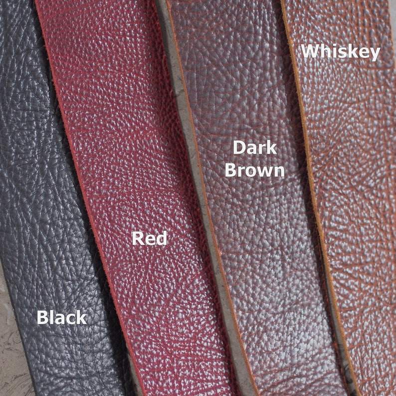 May include: Four leather strips in different colors: black, red, dark brown, and whiskey. The strips are arranged side-by-side, with the color names written below each strip.