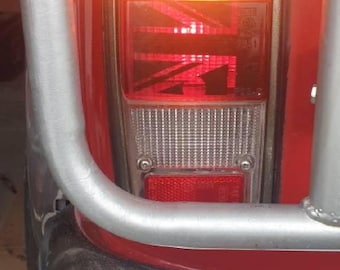 Puede incluir: Un coche rojo con un parachoques cromado y una luz trasera roja y blanca con el texto "9512" en ella.