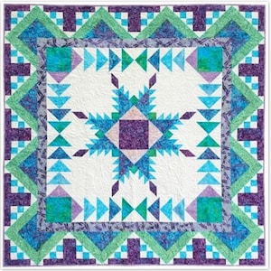 May include: A quilt with a starburst pattern in shades of blue, green, and purple. The quilt is made with a variety of fabrics, including some with a floral print.