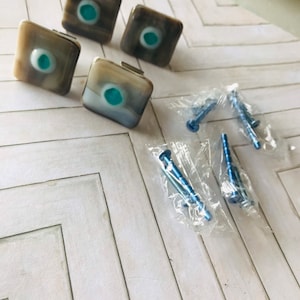 May include: A set of three ceramic mugs with a speckled, matte finish. The mugs are in shades of cream, light gray, and dark gray. Each mug has a simple, minimalist design, perfect for coffee or tea.