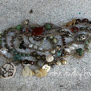 Peut inclure: Collier &agrave; plusieurs rangs orn&eacute; de perles vertes, marron, blanches et rouges. Il comprend des perles, des turquoises et des &eacute;l&eacute;ments d&eacute;coratifs uniques. Le texte "robin dudley howes" est visible.
