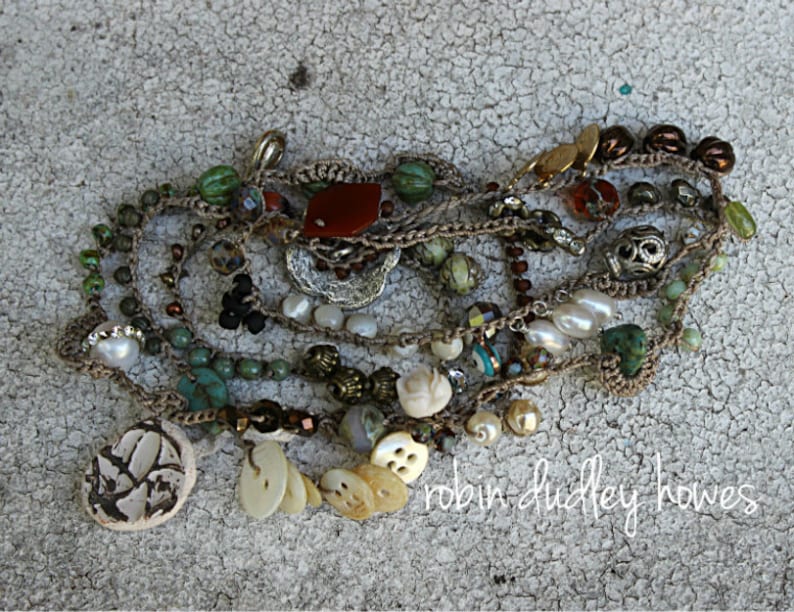 Peut inclure: Collier &agrave; plusieurs rangs orn&eacute; de perles vertes, marron, blanches et rouges. Il comprend des perles, des turquoises et des &eacute;l&eacute;ments d&eacute;coratifs uniques. Le texte "robin dudley howes" est visible.