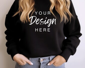 Puede incluir: Una sudadera negra con el texto "YOUR Design HERE" en letras blancas. La sudadera la lleva puesta una persona con el pelo largo y rubio.