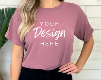 May include: A mauve colored t-shirt with short sleeves and a crew neck. The shirt has the text "YOUR Design HERE" printed on the front in white.