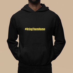 Può includere: Felpa con cappuccio nera con una grafica dorata #BringThemHome sul davanti.