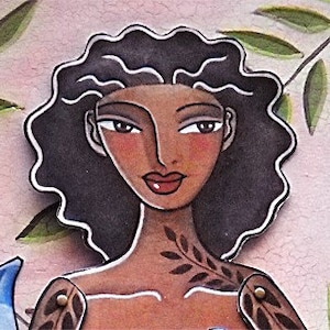 May include: A woman with dark brown hair and a leaf tattoo on her shoulder. She has brown skin and is wearing a light pink background.