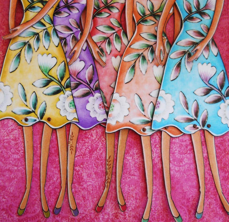 May include: Four colorful paper dolls with floral patterns on their dresses. The dolls are standing on a pink background.