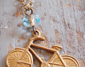 little vintage brass bicycle charm necklace. repurposed old bike charm & aqua blue czech glass bead on antiqued brass chain. ooak by val b.