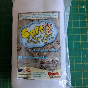 Puede incluir: Un paquete de guata de poliéster agujeteado blanco Soft & Bright de The Warm Company. La etiqueta indica que es 100% fibra de poliéster, no contiene pegamentos, resinas ni silicona, y mide 86 cm por 1,14 m. Fabricado en los Estados Unidos.