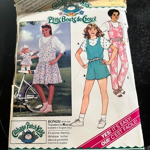 Può includere: Un modello di cucito vintage per abbigliamento Cabbage Patch Kids. Il modello è per un vestito a righe blu e bianche e una salopette a righe rosa e bianche. Il modello è di Butterick ed è di taglia 12-14.