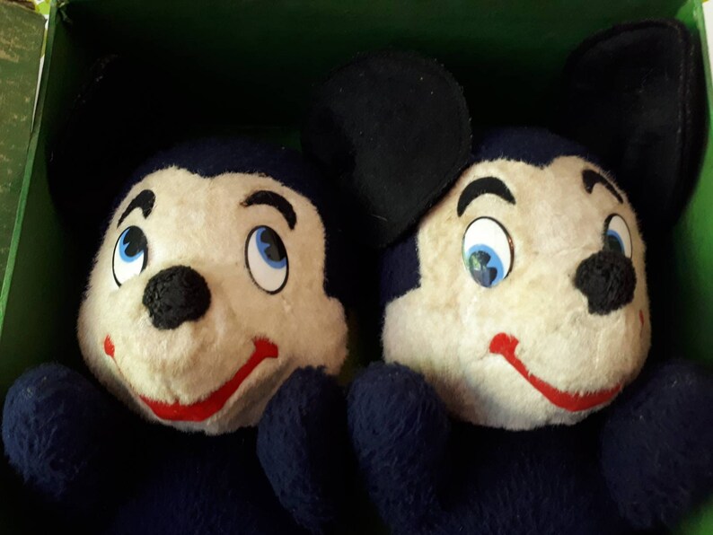 Puede incluir: Dos juguetes de peluche Mickey Mouse azules con orejas negras y caras blancas. Tienen narices negras, bocas rojas y ojos azules.