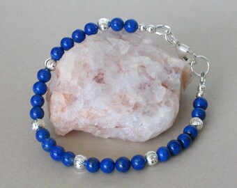 May include: A blue lapis lazuli beaded bracelet with silver accents and a silver clasp.