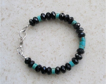 May include: A black and turquoise beaded bracelet with a silver clasp.