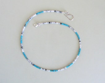 May include: A turquoise, white, and black beaded necklace with silver clasps.